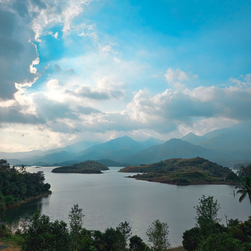 Speedboats on the reservoir at Banasura Sagar Dam with hills in background.