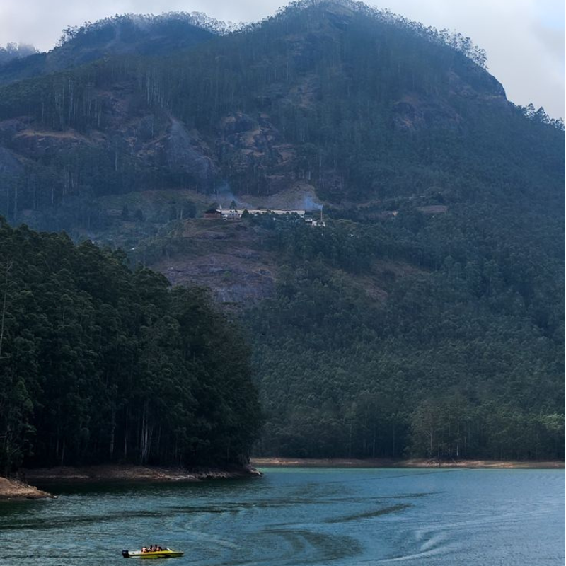 Speedboats on the water with mountain reflections at Mattupetty Dam